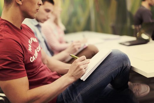 male student taking notes in classroom. business education concept, casual young businessman on seminar training