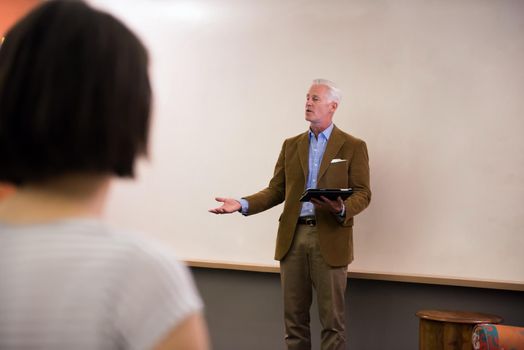 group of students study with professor in modern school classroom