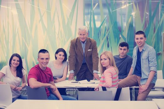 portrait of confident teacher,  students group in background