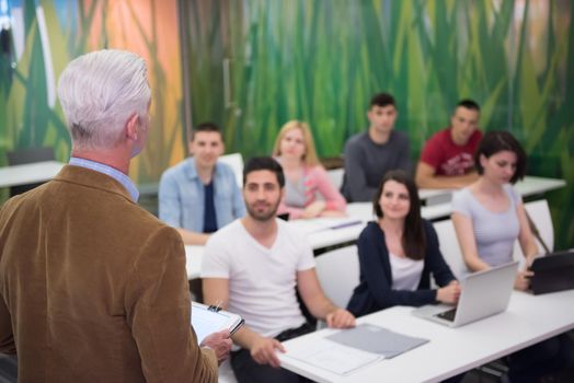 group of students study with professor in modern school classroom