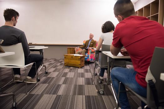 group of students study with professor in modern school classroom