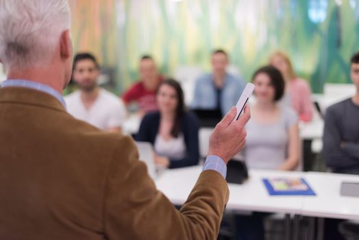 group of students study with professor in modern school classroom