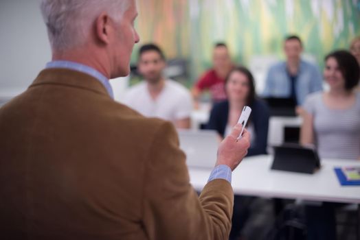 group of students study with professor in modern school classroom