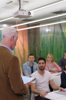 group of students study with professor in modern school classroom