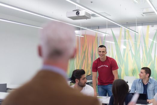 group of students study with professor in modern school classroom