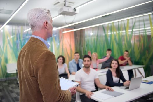 group of students study with professor in modern school classroom