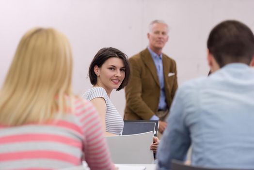 group of students study with professor in modern school classroom