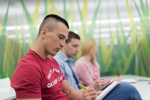 male student taking notes in classroom. business education concept, casual young businessman on seminar training