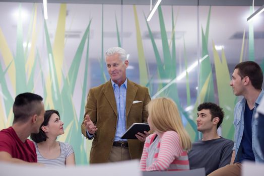 group of students study with professor in modern school classroom