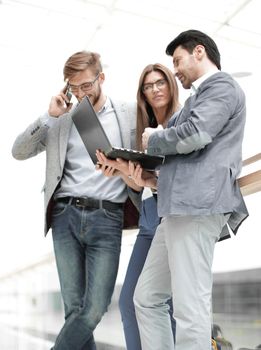 business colleagues using their gadgets standing in the office lobby. photo with copy space