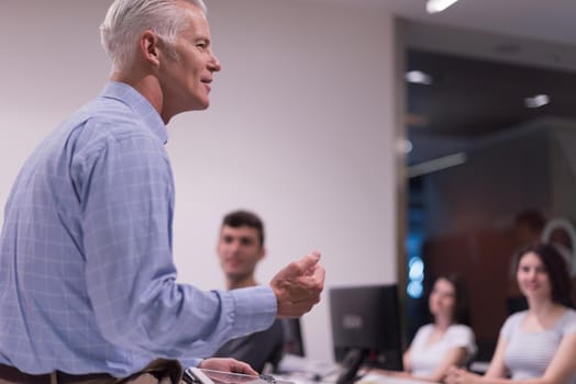 handsome mature teacher and students in computer lab classroom