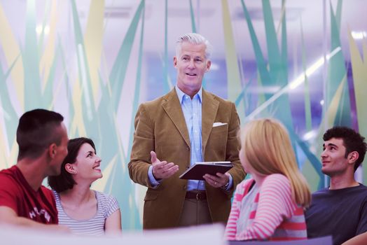 group of students study with professor in modern school classroom