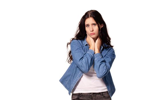 Beautiful and unhappy young woman with dark wavy hair looking into the camera with serious expression on her face. Isolated on white background.