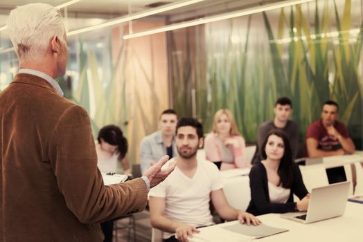 group of students study with professor in modern school classroom