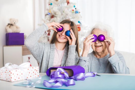 granddaughter in santa hat playing decorative balls at Christmas