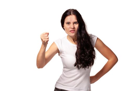 The portrait the young beautiful woman threatens with a fist is isolated on white