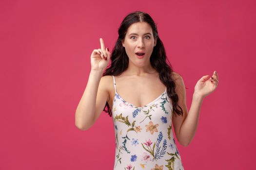 Smiling serious girl holding her index finger in front, saying: I have idea on the pink background