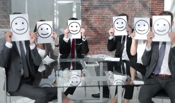 business team keeps smiley icons sitting at the Desk.business concept