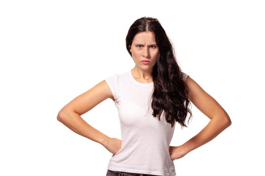 Angry girl standing with hands on waist and looking at camera isolated on white