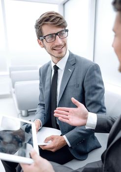 contemporary business people working connected with technological devices like tablet and laptop, talking together - finance, business, technology concept