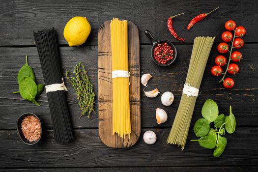 Multi colored pasta set, on black wooden table background, top view flat lay