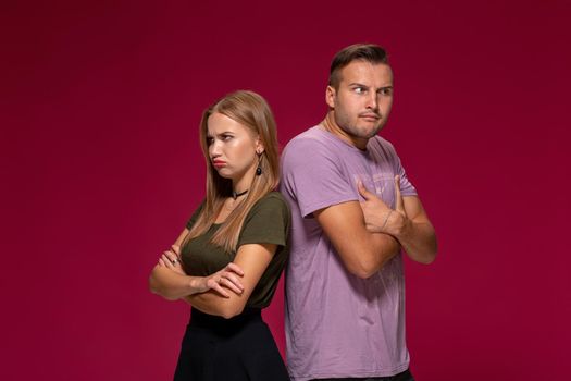 Studio portrait of a young couple in casual wear quarreled and taking a step towards reconciliation. The problem of relationships, quarrels, difficulties in communication