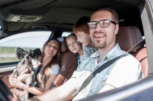 side view.happy father driving a family car .the concept of freedom and travel