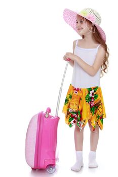 Smiling little girl in a pink hat and white tank top without a pattern . Girl holding hand pink suitcase - Isolated on white background