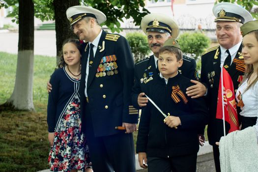 PYATIGORSK, RUSSIA - MAY 09, 2017: Children are photographed with veterans sailors in medals on a victory day