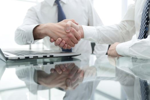 close up.colleagues shaking hands over a Desk .photo with copy space