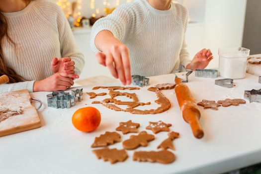 Christmas bakery. Friends making gingerbread, cutting cookies of gingerbread dough, view from above. Festive food, cooking process, family culinary, Christmas and New Year traditions concept