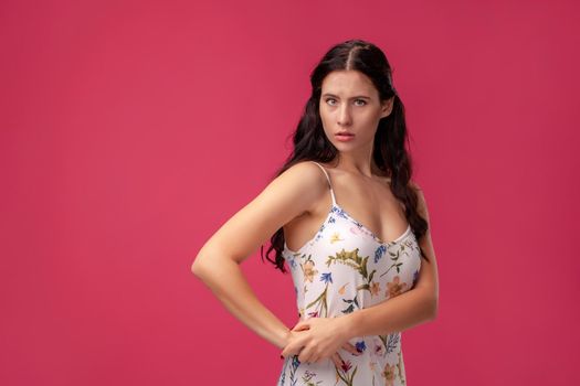 Pretty slim girl proud of herself, studio photo on the pink background