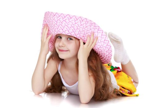 Cute little girl in pink hat lies on the floor-Isolated on white background