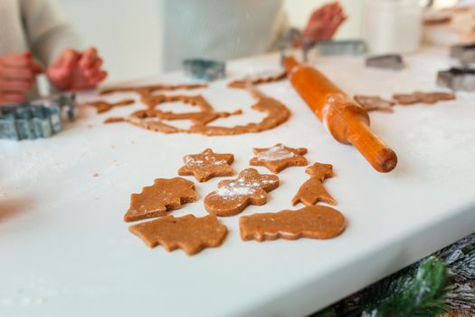 Christmas bakery. Friends making gingerbread, cutting cookies of gingerbread dough, view from above. Festive food, cooking process, family culinary, Christmas and New Year traditions concept