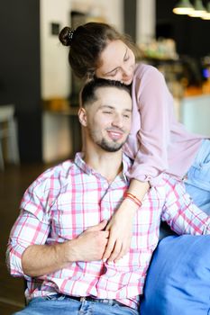 Young wife sitting with man and hugging. oncept of spending time together and love.