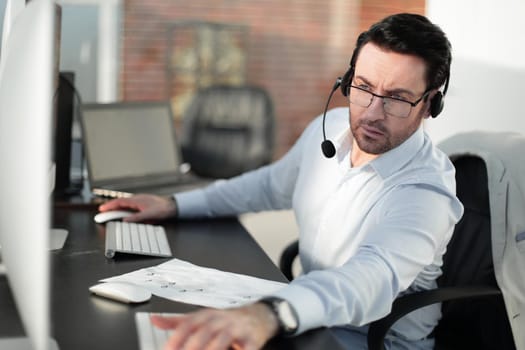 close up.businessman with a headset sitting at his Desk.people and technology