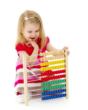 Cute little girl is playing with wooden abacus at home. An intelligent child learns to count. She enjoys with an educational toy at home or in kindergarten. Isolated on white background.