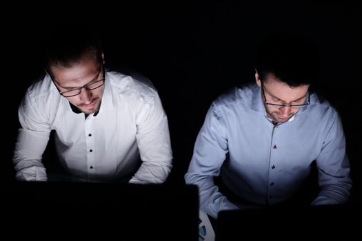 close up.two colleagues working on computers.isolated on black