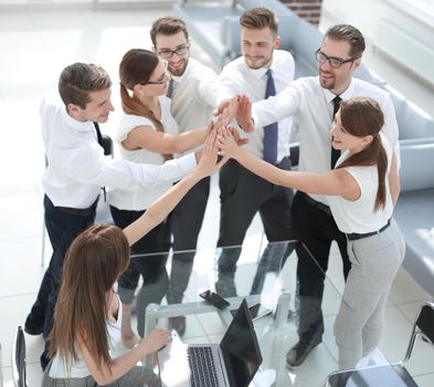 happy business team putting their hands together .the concept of teamwork