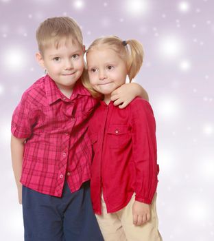 The concept of celebrating the New year, Holy Christmas, or child's birthday on a purple background and white snowflakes.Little brother and sister cute hug.