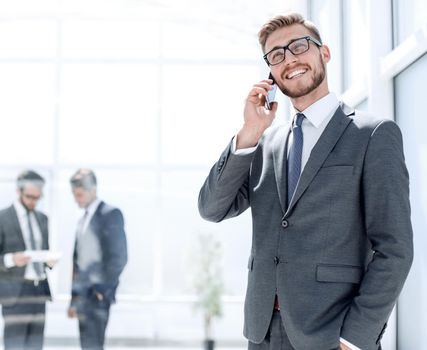 businessman with mobile phone standing next to the Bank office .photo with copy space