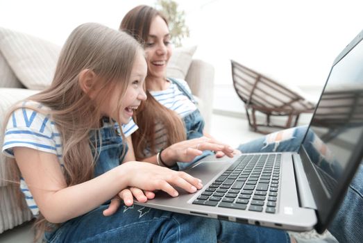 childhood, parenting and technology concept - happy mother with adorable little girl with laptop