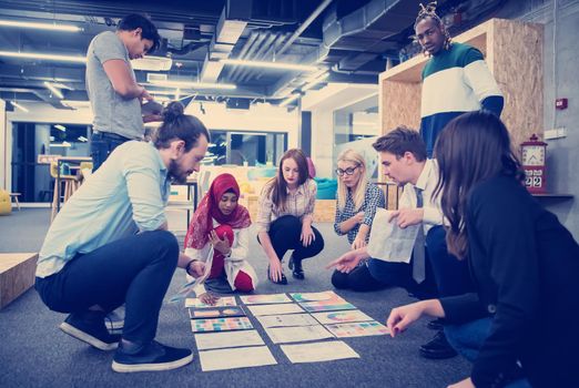 young black muslim businesswoman having meeting with her multiethnic startup business team in modern office interior,presenting new ideas on the floor