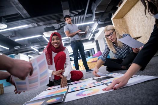 young black muslim businesswoman having meeting with her multiethnic startup business team in modern office interior,presenting new ideas on the floor