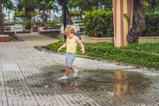 Little boy runs through a puddle. summer outdoor.