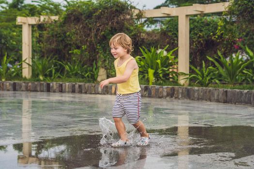 Little boy runs through a puddle. summer outdoor.