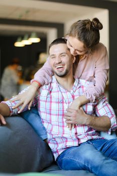 Young wife kissing and hugging husband at home. Concept of spending time together, relationship and love.