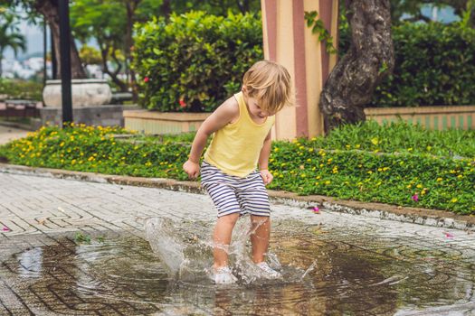 Little boy runs through a puddle. summer outdoor.