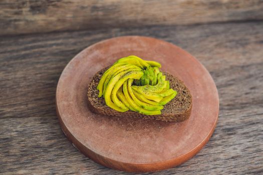 Avocado sandwich on dark rye bread made with fresh sliced avocados.