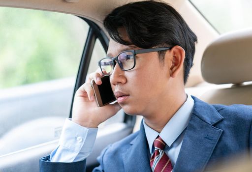 Young asian business men portrait in suit  talking on the phone in car